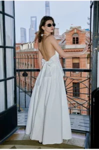 Vacation style hanging neck dress with hollowed out embroidery, exposed back, cinched waist, slimming effect, and large A-line long skirt