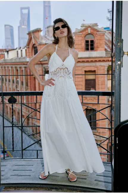 Vacation style hanging neck dress with hollowed out embroidery, exposed back, cinched waist, slimming effect, and large A-line long skirt